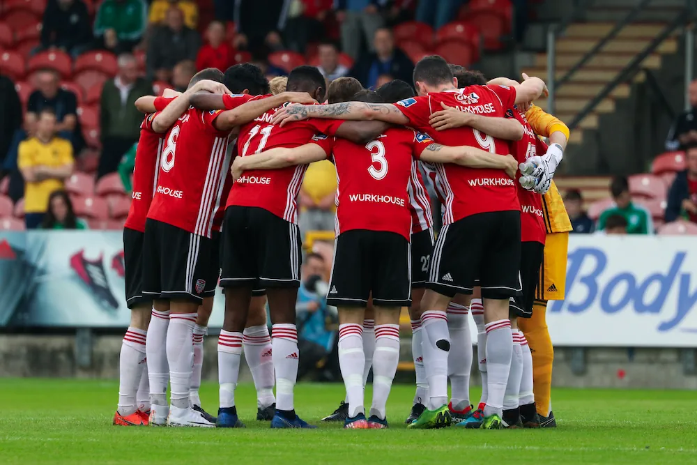 Derry City-spelare peppar varandra före en match