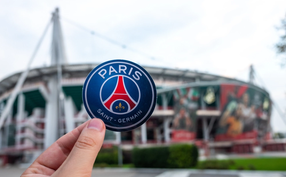 Paris Saint-Germain logo med deras stadium i bakgrunden