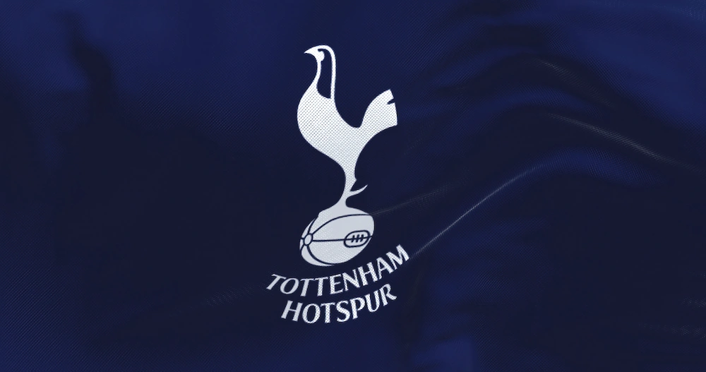 Tottenham Hotspurs vita logotyp på mörkblå tröja