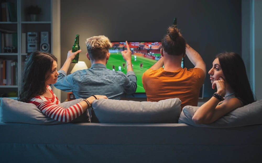 Vänner tittar på fotbollsmatch på TV